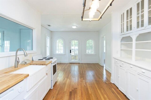 kitchen featuring a chandelier, decorative light fixtures, electric stove, white cabinets, and light wood-type flooring