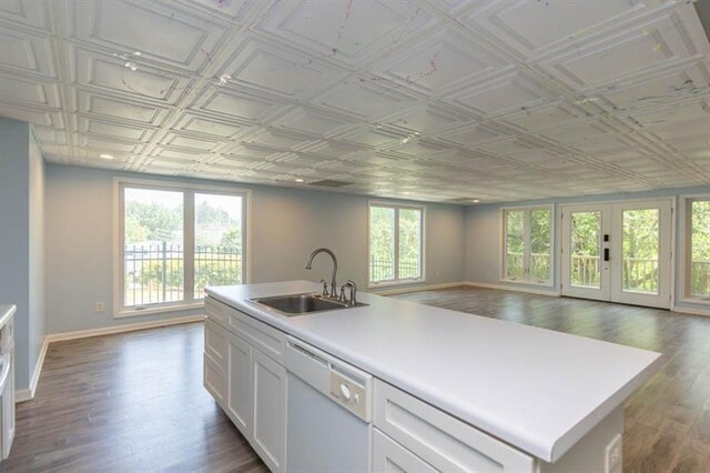 kitchen with white cabinetry, sink, white dishwasher, and a healthy amount of sunlight