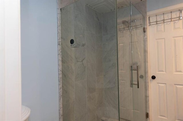 bathroom featuring a shower with door