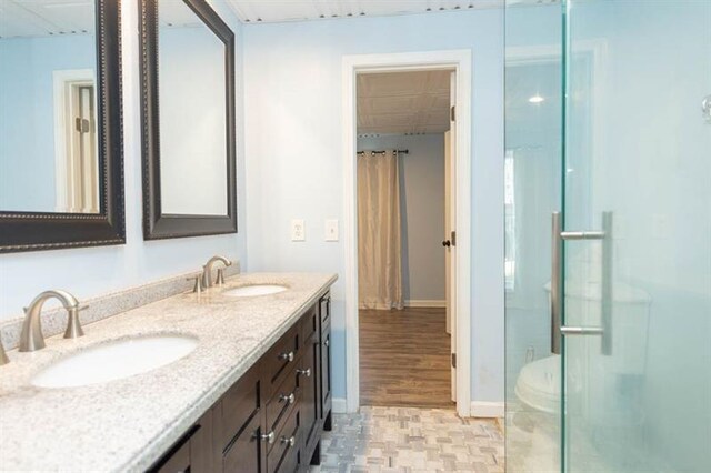 bathroom featuring hardwood / wood-style flooring, vanity, and walk in shower