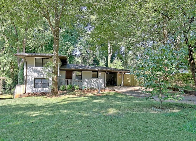 tri-level home featuring a carport, a front yard, fence, and driveway