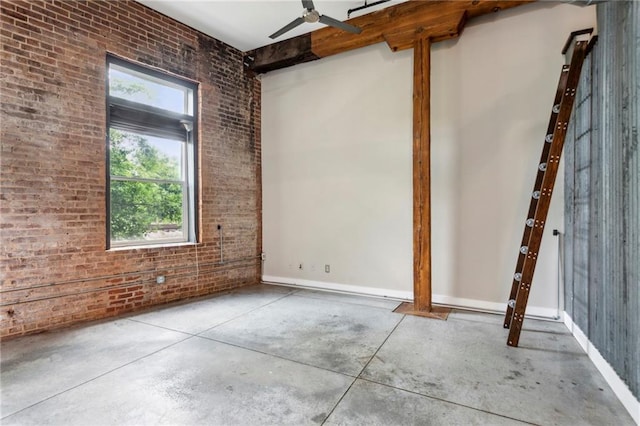 unfurnished room with concrete flooring, brick wall, and ceiling fan
