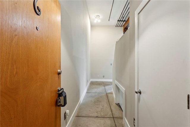 hall with baseboards and concrete flooring