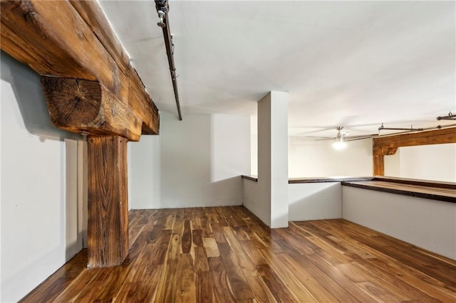 below grade area featuring track lighting and wood finished floors