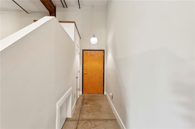 doorway featuring baseboards and concrete floors