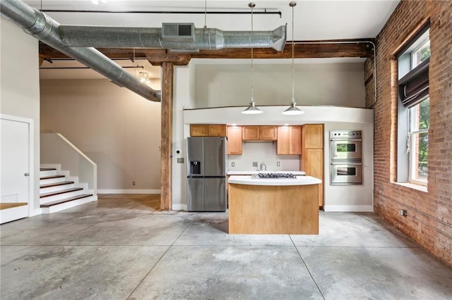 kitchen with a center island, appliances with stainless steel finishes, brick wall, and concrete flooring