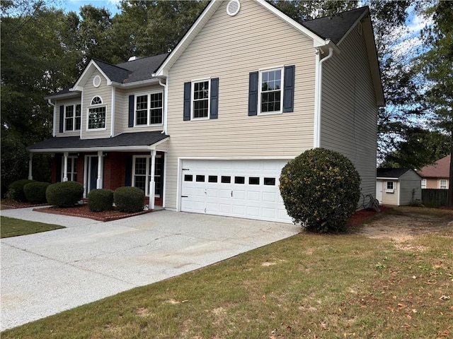 view of front property featuring a porch, a garage, and a front yard