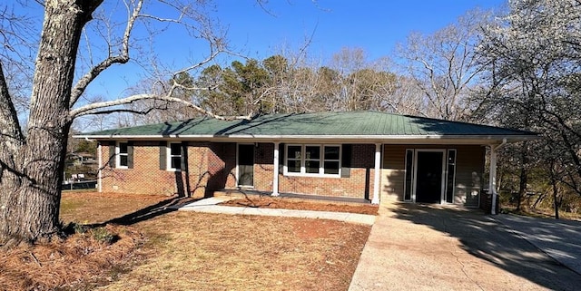 ranch-style home featuring metal roof and brick siding