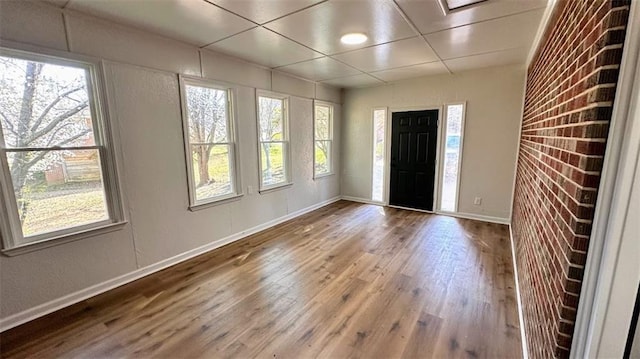 foyer entrance with wood finished floors and baseboards