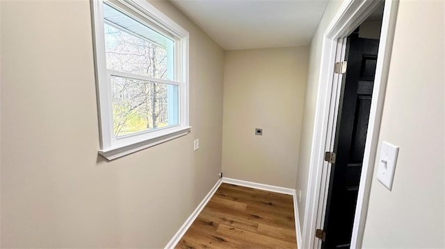 corridor featuring wood finished floors and baseboards