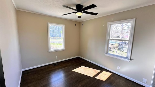 unfurnished room with a ceiling fan, visible vents, baseboards, dark wood finished floors, and crown molding