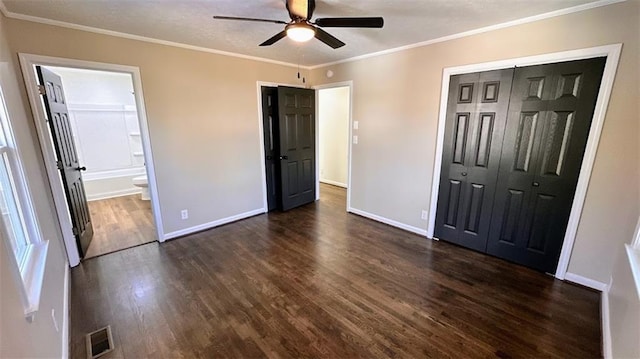 unfurnished bedroom with dark wood finished floors, visible vents, baseboards, and ornamental molding