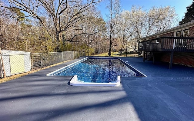 view of swimming pool featuring a deck, a fenced in pool, and fence