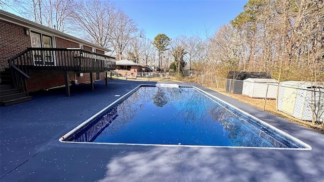 view of pool with a fenced in pool, a wooden deck, stairs, and fence