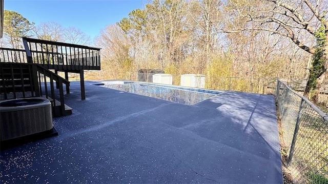 view of swimming pool featuring fence, stairway, a wooden deck, a fenced in pool, and central AC unit