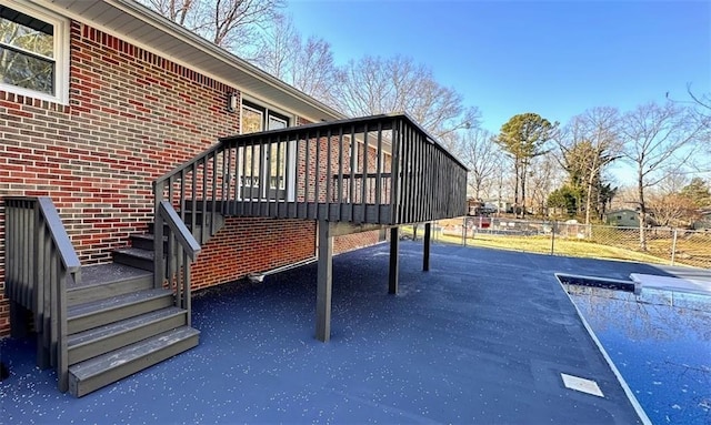 exterior space featuring a swimming pool, stairway, and fence