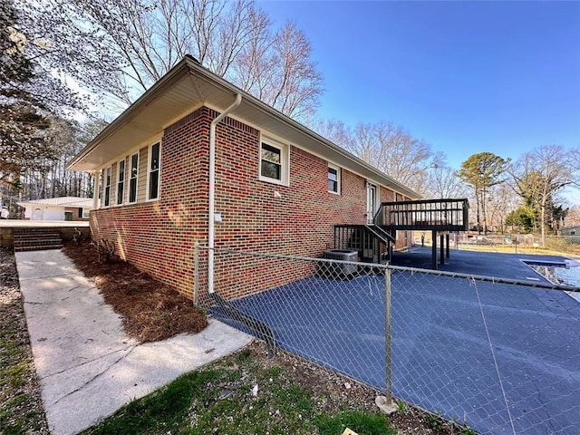 view of side of property with brick siding, stairway, and a wooden deck