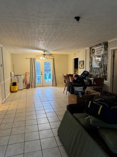 tiled living room featuring french doors, ceiling fan, and a textured ceiling