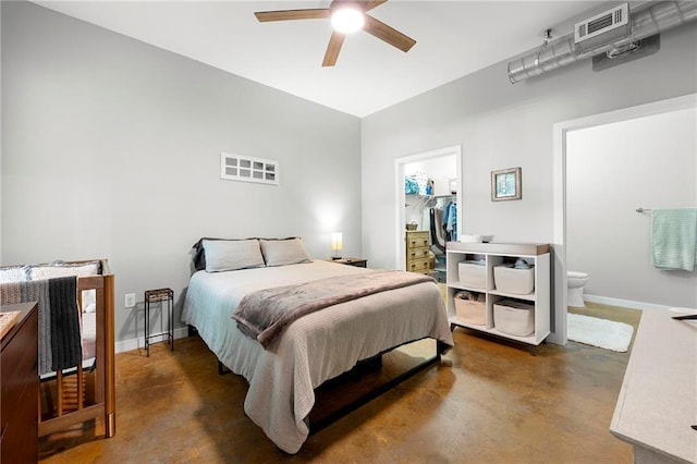 bedroom with finished concrete floors, a spacious closet, baseboards, and a closet