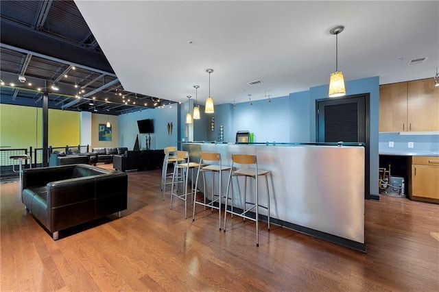 kitchen with wood finished floors, open floor plan, and decorative light fixtures