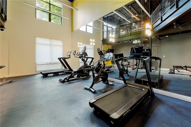 exercise room featuring a high ceiling and baseboards