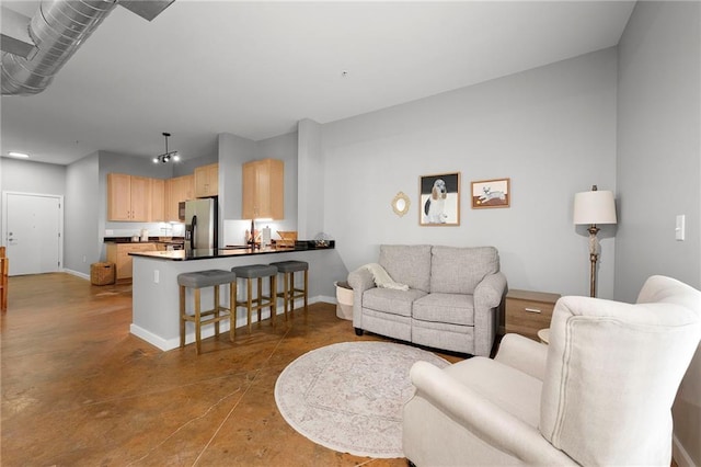 living area with baseboards, finished concrete floors, and recessed lighting