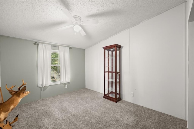 unfurnished room with ceiling fan, a textured ceiling, and carpet floors