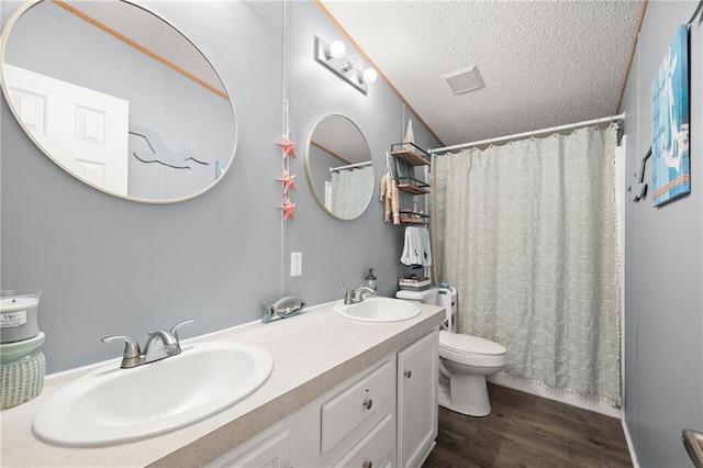 bathroom with toilet, a textured ceiling, hardwood / wood-style flooring, vanity, and walk in shower