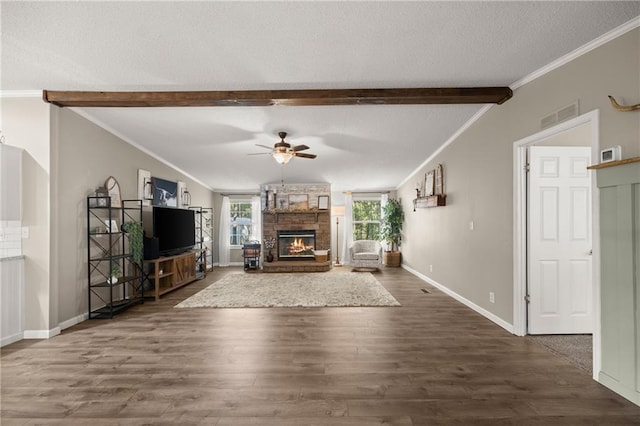 unfurnished living room with a stone fireplace, dark hardwood / wood-style flooring, a textured ceiling, and beam ceiling