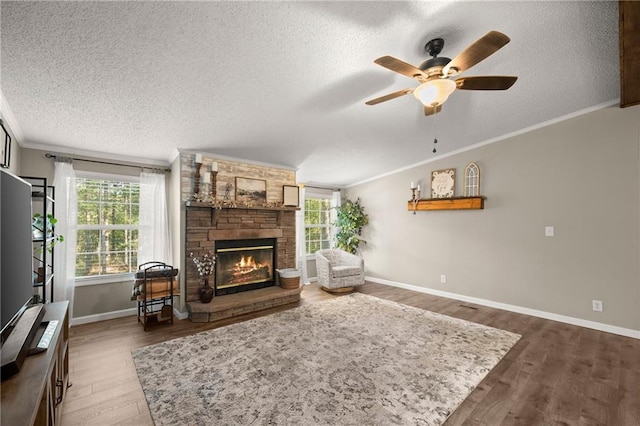 living room featuring ornamental molding, a stone fireplace, a textured ceiling, and dark hardwood / wood-style floors