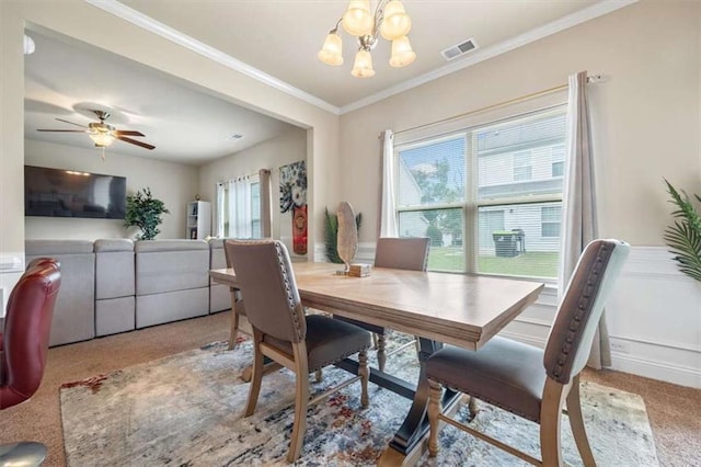 dining space with carpet, visible vents, crown molding, and ceiling fan with notable chandelier