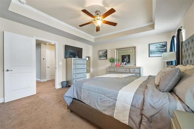 bedroom with a tray ceiling, carpet flooring, crown molding, and baseboards