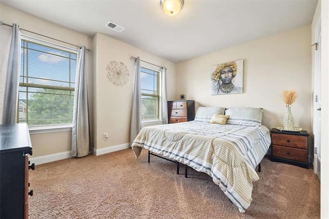 carpeted bedroom with visible vents and baseboards