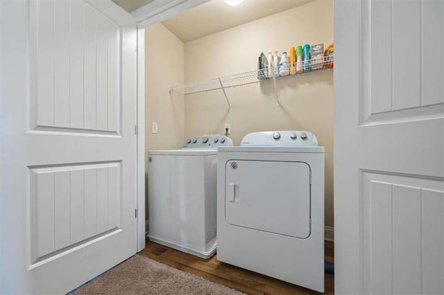 washroom featuring laundry area, wood finished floors, and washing machine and clothes dryer