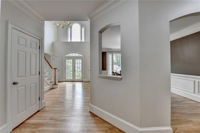 12130 Helleri Holw, Alpharetta, GA 30005 - foyer entrance featuring crown molding, arched walkways, a chandelier, light wood finished floors, and stairs