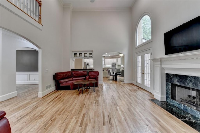 12130 Helleri Holw, Alpharetta, GA 30005 - living area featuring a high ceiling, arched walkways, ornamental molding, wood finished floors, and baseboards