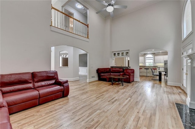 12130 Helleri Holw, Alpharetta, GA 30005 - living area featuring arched walkways, a ceiling fan, a towering ceiling, light wood-type flooring, and baseboards