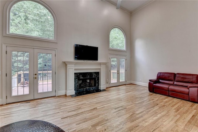12130 Helleri Holw, Alpharetta, GA 30005 - living area with french doors, a towering ceiling, wood finished floors, a fireplace, and crown molding