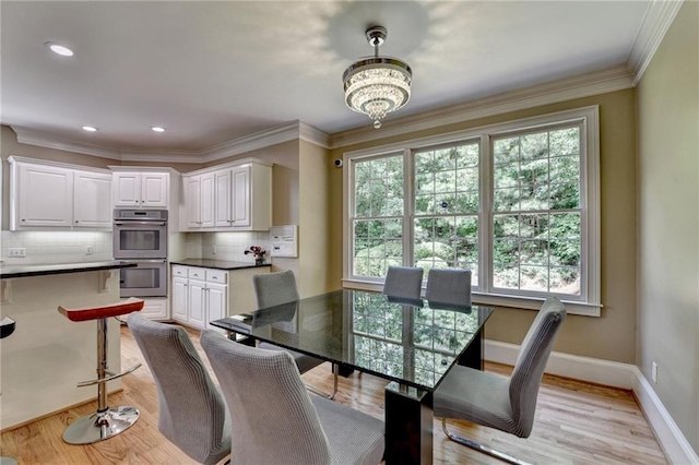 12130 Helleri Holw, Alpharetta, GA 30005 - dining space featuring plenty of natural light, baseboards, a chandelier, light wood-type flooring, and crown molding