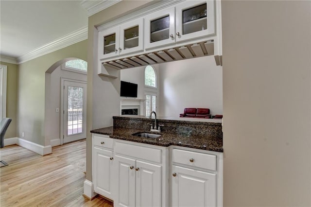 12130 Helleri Holw, Alpharetta, GA 30005 - kitchen featuring a sink, arched walkways, white cabinets, dark stone counters, and ornamental molding
