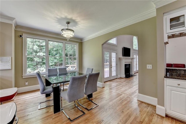 12130 Helleri Holw, Alpharetta, GA 30005 - dining space featuring arched walkways, crown molding, baseboards, light wood-type flooring, and a premium fireplace