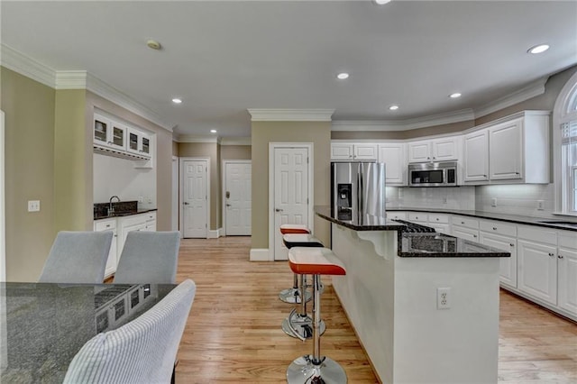 12130 Helleri Holw, Alpharetta, GA 30005 - kitchen with stainless steel appliances, light wood finished floors, white cabinets, a sink, and a breakfast bar area