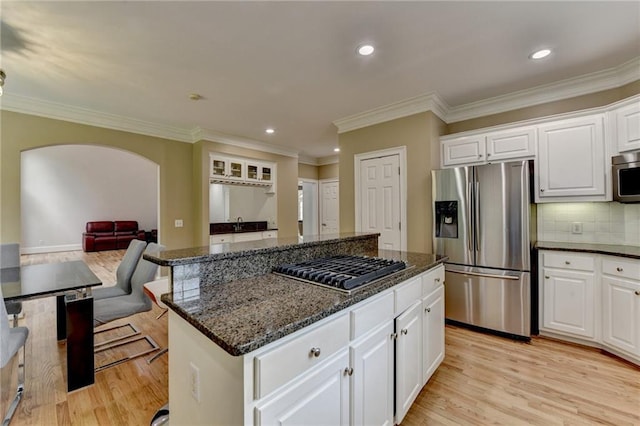 12130 Helleri Holw, Alpharetta, GA 30005 - kitchen with appliances with stainless steel finishes, a kitchen island, open floor plan, dark stone countertops, and light wood-type flooring
