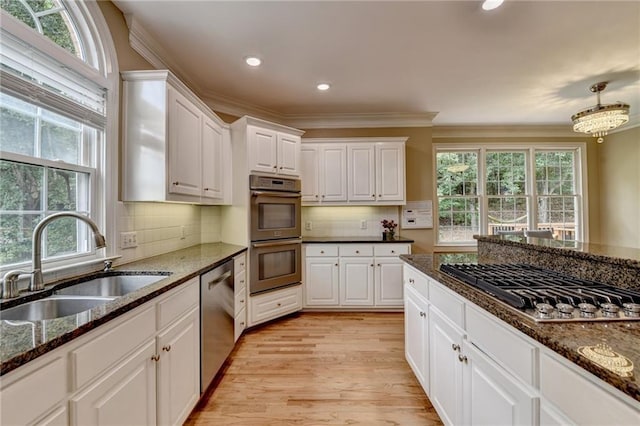 12130 Helleri Holw, Alpharetta, GA 30005 - kitchen featuring appliances with stainless steel finishes, a sink, plenty of natural light, white cabinets, and ornamental molding