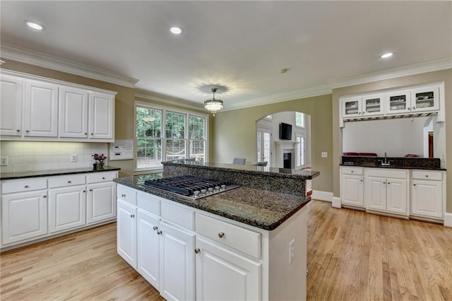 12130 Helleri Holw, Alpharetta, GA 30005 - kitchen featuring stainless steel gas stovetop, light wood-type flooring, arched walkways, crown molding, and white cabinets