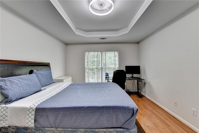 12130 Helleri Holw, Alpharetta, GA 30005 - bedroom featuring a tray ceiling, wood finished floors, and baseboards