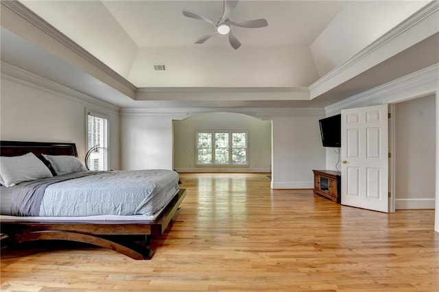 12130 Helleri Holw, Alpharetta, GA 30005 - bedroom featuring multiple windows, light wood-style floors, a tray ceiling, baseboards, and crown molding