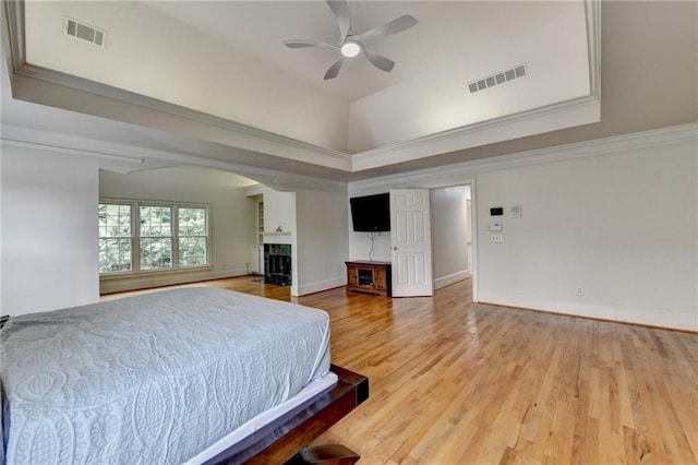 12130 Helleri Holw, Alpharetta, GA 30005 - bedroom with a fireplace, arched walkways, light wood-style flooring, baseboards, and ceiling fan