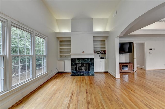 12130 Helleri Holw, Alpharetta, GA 30005 - unfurnished living room with plenty of natural light, light wood-style flooring, baseboards, a fireplace, and crown molding