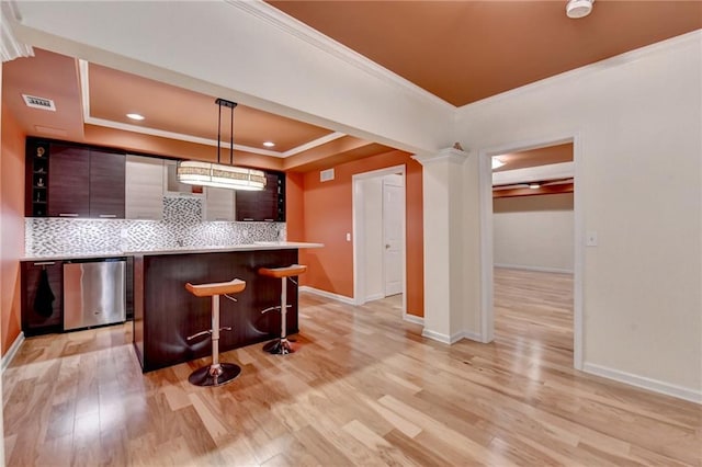 12130 Helleri Holw, Alpharetta, GA 30005 - kitchen with a breakfast bar area, crown molding, backsplash, light wood-style floors, and modern cabinets